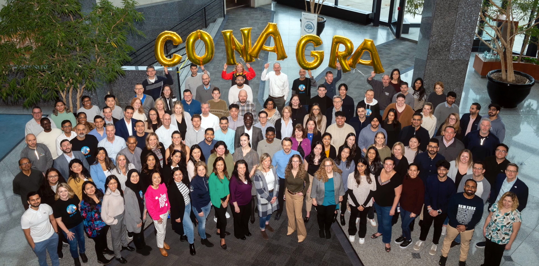 Group of people outside holding a Conagra baloon